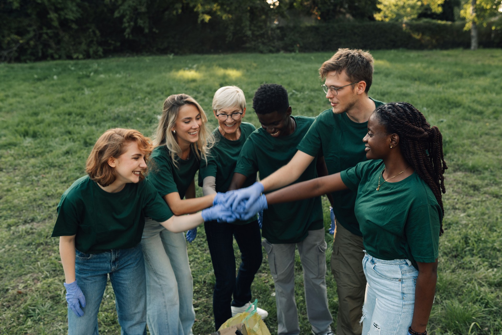 Volunteers putting hands together after cleaning park